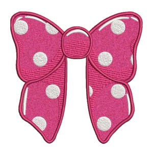 May include: A pink bow with white polka dots, outlined in a darker pink. The bow is a decorative element, possibly for crafts or embellishments. The design is embroidered with a textured appearance.