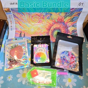 May include: A "Basic Bundle" diamond painting kit with a colorful abstract design. The kit includes a canvas, various bags of gems, and tools. The canvas features a vibrant, swirling pattern in shades of yellow, orange, and blue.