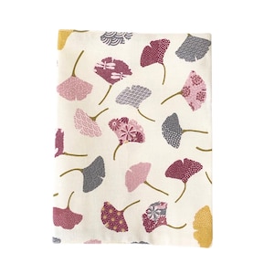 May include: Cream-coloured fabric featuring a repeating pattern of stylised ginkgo leaves in shades of pink, burgundy, grey, and gold. The leaves have various geometric and floral designs. The fabric is likely for home decor or crafting.