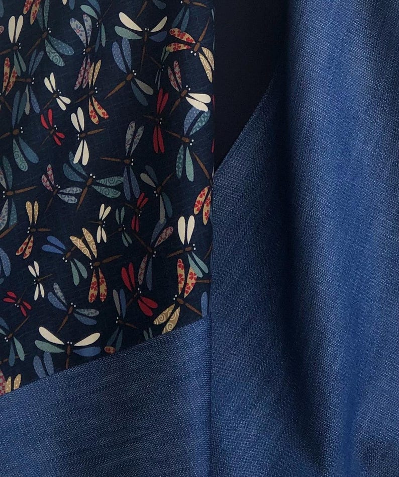 Puede incluir: Primer plano de una tela con un estampado de lib&eacute;lulas en azul marino, blanco, rojo y beige. La tela est&aacute; junto a una tela azul liso. La tela de lib&eacute;lulas se utiliza probablemente para ropa o decoraci&oacute;n del hogar.