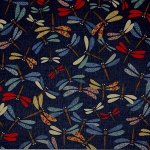 Puede incluir: Tela azul oscuro con un patr&oacute;n repetido de lib&eacute;lulas coloridas. Las lib&eacute;lulas tienen alas en tonos rojos, amarillos, azules y verdes, con cuerpos marrones. La tela tiene una apariencia texturizada.