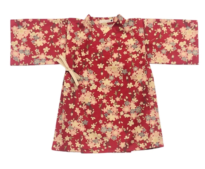 May include: A red kimono with a floral pattern. The kimono has a white sash and is made of a soft, lightweight fabric.
