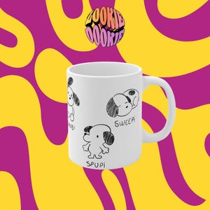 May include: White ceramic mug featuring black and white cartoon dog illustrations with the words "Wubi", "Sweep", and "Spupi". The mug has a white handle and is set against a yellow and purple wavy background. The text "Zookie Zookie" is at the top.