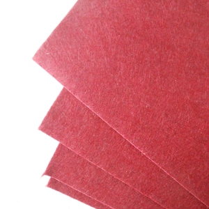 May include: Four sheets of red felt fabric stacked on top of each other.