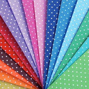 Puede incluir: Un abanico de hojas de fieltro de colores con lunares blancos. Las hojas están dispuestas en forma de arcoíris, con colores que van del verde al rojo.