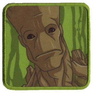 May include: A close-up of a brown and green embroidered patch featuring a character from the Guardians of the Galaxy movie. The character has a large, brown head with a serious expression and a green background.