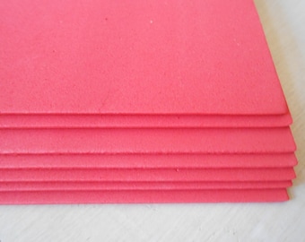 May include: A stack of six bright pink foam sheets.