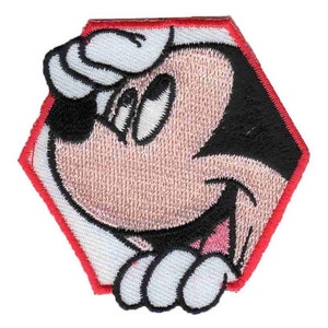 May include: A red, white, and black embroidered patch featuring Mickey Mouse peeking out from behind a white background. Mickey Mouse is wearing a white sailor hat and has a black nose and eyes.