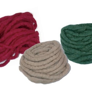 Op de afbeelding: Drie bollen garen in rood, beige en groen. Het garen is dik en chunky, perfect om te breien of te haken.