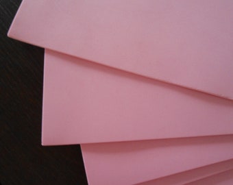 May include: Stack of pink foam sheets, layered on top of each other.