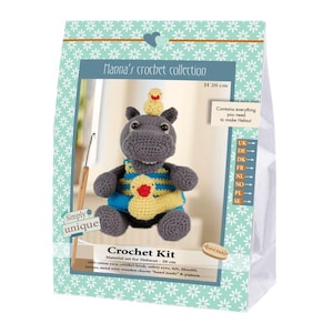 Può includere: Un kit per uncinetto per un ippopotamo di 20 cm chiamato Helmut, confezionato in una scatola azzurra con motivi a fiori bianchi. Il kit include filato di cotone, un uncinetto, occhi di sicurezza, feltro, imbottitura, filo metallico e uno schema.