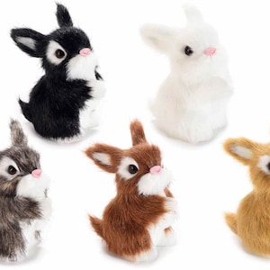Puede incluir: Cinco figuritas de conejo de peluche en diferentes colores: negro, blanco, marrón, gris y tostado. Los conejos están todos sentados en posición vertical con las orejas levantadas.