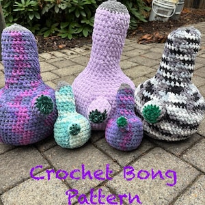 Può includere: Cinque articoli bong all'uncinetto in peluche di varie dimensioni e colori, tra cui filato viola, azzurro e screziato bianco e nero. Ogni pezzo presenta un piccolo accento circolare verde. Il testo "Crochet Bong Pattern" è scritto in viola.