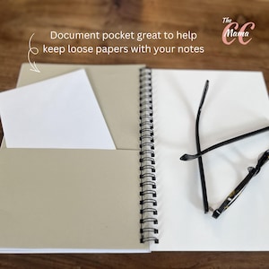 May include: Open notebook with a spiral binding, featuring a document pocket holding a white paper. The notebook is open to a blank page, with a pair of black eyeglasses resting on the page. Text on the image reads: Document pocket great to help keep loose papers with your notes.