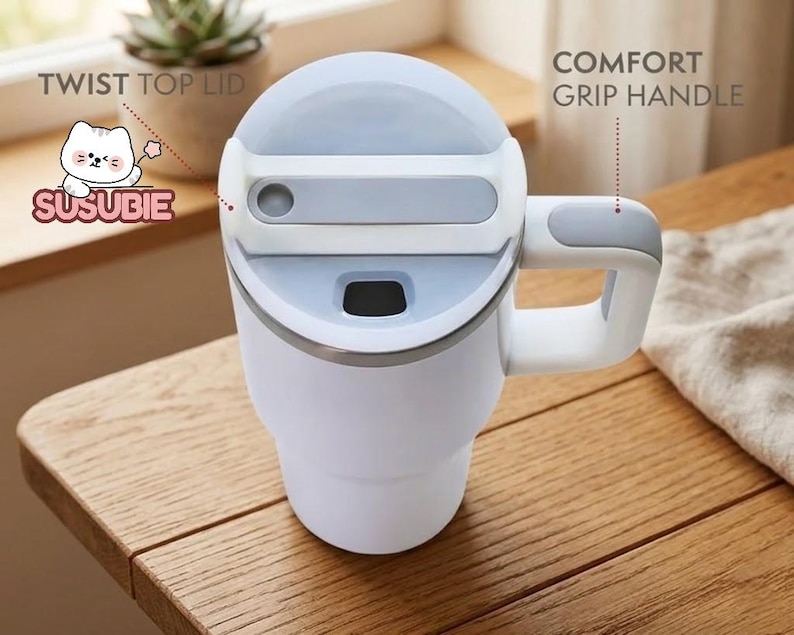 A white and gray insulated travel mug with a twist-top lid and a comfortable grip handle, placed on a wooden table.