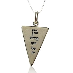 May include: Silver necklace with a triangular pendant featuring Hebrew text. The pendant is inscribed with the words "May you be blessed with good fortune".