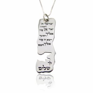 Pode incluir: Colar de prata com um pingente em forma do contorno de Israel. O pingente é gravado com texto hebraico, incluindo a palavra "Shalom", que significa paz.