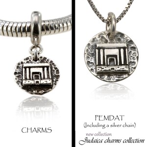 May include: Silver charm pendant featuring a detailed depiction of the Western Wall, a significant Jewish site in Jerusalem. The charm is attached to a silver chain and is part of a Judaica charms collection.
