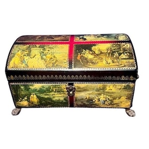 May include: A rectangular storage chest with a curved lid, featuring dark brown surfaces decorated with multiple panels of pastoral scenes in yellow and green tones. The chest has a central metal keyhole plate and four small, ornate feet at the base.