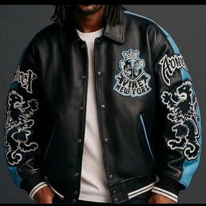 May include: Black leather jacket with light blue detailing on the sleeves and collar. It features embroidered lion graphics and the text "AVIREY NEW YORK". The jacket has a button-up front and a ribbed hem.