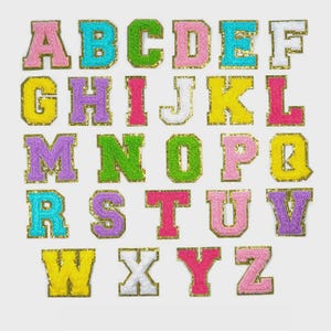 Peut inclure: Un ensemble de lettres de l'alphabet brodées et colorées. Chaque lettre est d'une couleur différente, notamment rose, vert, bleu, jaune et violet, avec une bordure dorée scintillante. Les lettres sont de style bloc.
