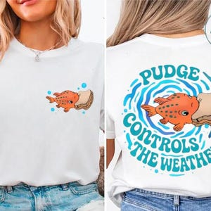 The image is a collage of two photos. In the first photo, a woman is wearing a white t-shirt with a graphic of an orange fish and the text "Pudge Controls the Weather" printed on it. In the second photo, the woman is wearing a white t-shirt with a graphic of an orange fish and the text "Pudge Controls the Weather" printed on it, but the text is upside down.