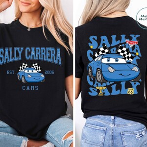 The image is a collage of two photos. In the first photo, a woman is wearing a black t-shirt with a graphic of a blue car and the text "Sally Carrera" and "Cars" printed on it. In the second photo, the woman is wearing a black t-shirt with a graphic of a blue car and the text "Sally Carrera" and "Cars" printed on it, along with a checkered flag and a trophy.