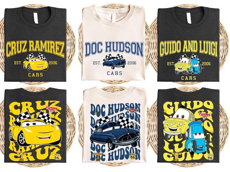 six t-shirts, each featuring a different cartoon character from the Cars movie franchise. The characters include Cruz Ramirez, Doc Hudson, Guido and Luigi, and other well-known characters from the animated series.
