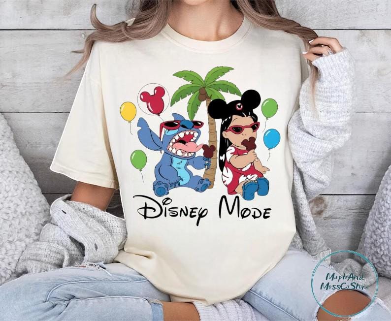 A woman wearing a white t-shirt with a Disney-themed graphic design featuring characters from the Disney movie Lilo and Stitch.