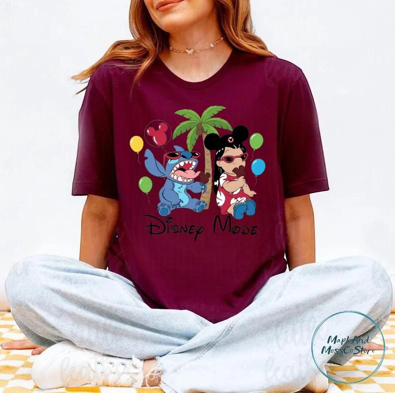 A woman wearing a maroon t-shirt with a Disney-themed graphic of characters from the movie Lilo & Stitch.