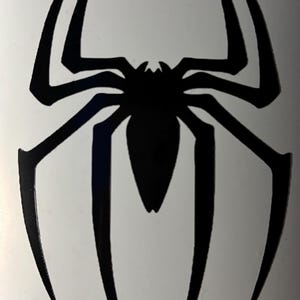 May include: A black spider emblem with eight elongated legs and a central body. The design is a stylized, symmetrical representation of a spider, suitable for decals, stickers, or graphic applications.