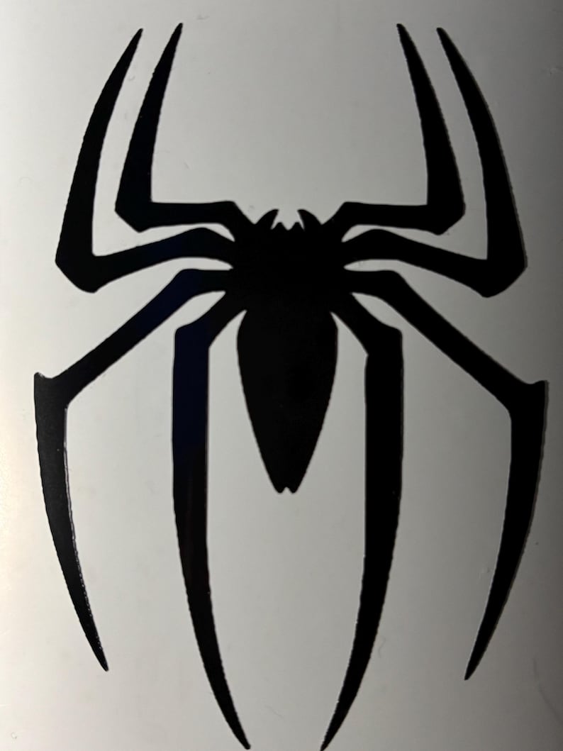 May include: A black spider emblem with eight elongated legs and a central body. The design is a stylized, symmetrical representation of a spider, suitable for decals, stickers, or graphic applications.