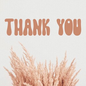 May include: A light beige background with the words "THANK YOU" in a rounded, orange-brown font. Below the text is a cluster of dried, light brown ornamental grass.