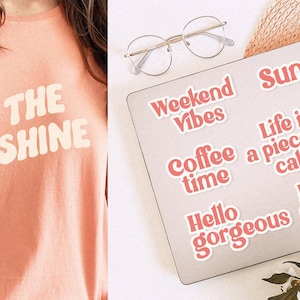 May include: A peach-colored t-shirt with the text "BE THE SUNSHINE" in white. A laptop with stickers that say "Weekend Vibes", "Coffee time", "Hello gorgeous", "Sunshine", "Life is a piece of cake", and "Little Cutie".