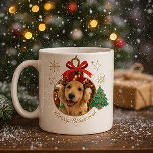 May include: A white ceramic mug with a festive Christmas design. The mug features a golden retriever wearing a reindeer antler headband inside a Christmas ornament. The words "Merry Christmas" are written in a script font. A small green Christmas tree is also on the mug.