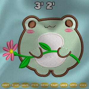 Puede incluir: Diseño de rana bordada con una flor rosa y hojas verdes. La rana es verde claro con contornos marrones y mejillas rosas. El texto "3' 2" está encima de la rana. Debajo están las letras "DST EXP HUS PES SEW TAP U03 VP3 XXX".