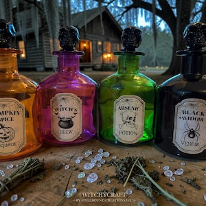 May include: Four glass apothecary bottles with skull-shaped stoppers. The orange bottle is labeled Pumpkin Spice Liqueur, the purple bottle Witch's Brew, the green bottle Arsenic Potion, and the black bottle Black Widow Venom with spider graphics.