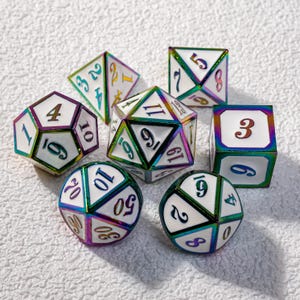 May include: A collection of seven polyhedral dice for tabletop games. The dice have a white base with iridescent edges and numbers in various colors. The dice include a d4, d6, d8, d10, d12, d20, and a percentile die.