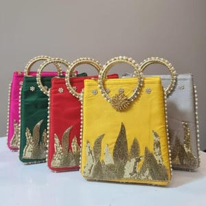 Peut inclure: Plusieurs sacs à main colorés et ornés. Chaque sac présente une forme rectangulaire, une anse circulaire ornée de perles et des détails complexes en or et perles. Les sacs sont disponibles en rose, vert, rouge, jaune et gris.