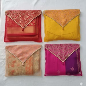 May include: Four fabric pouches in red, yellow, peach, and pink, each with a decorative flap. The flaps feature floral patterns and gold trim. The pouches are made of sheer fabric, revealing the contents within.