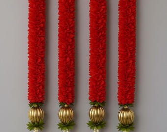 Puede incluir: Cuatro guirnaldas florales rojas verticales con detalles dorados. Cada guirnalda tiene un orbe dorado en la base, con hebras de cuentas blancas y flores rojas. Las guirnaldas cuelgan de anillos dorados.