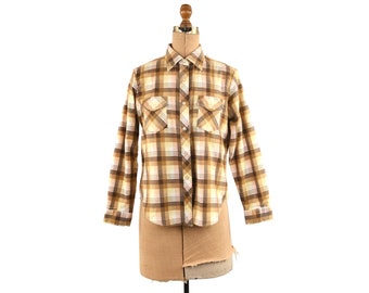 May include: A long-sleeved plaid shirt with brown, white, and orange checks. The shirt has a button-down collar and two chest pockets.