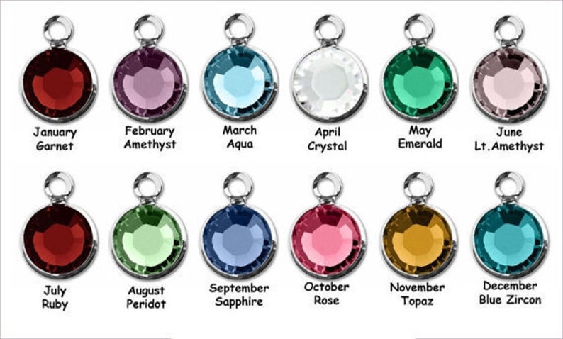 May include: Twelve round, faceted gemstone charms, each representing a different month of the year. The charms are silver-toned and feature a variety of colors, including red, blue, green, pink, and purple.