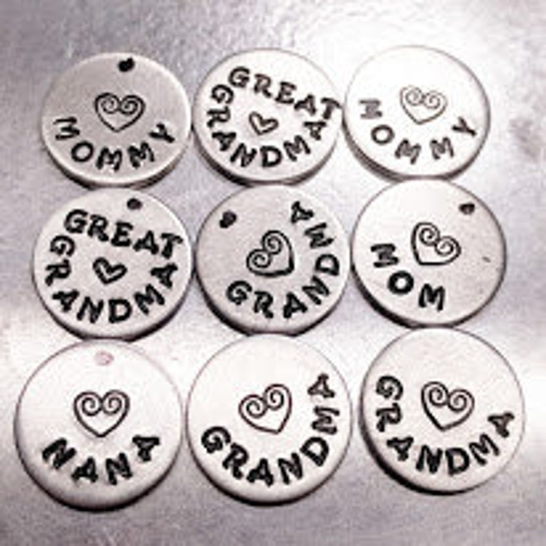 May include: Nine silver-toned metal charms with different words and a heart design. The words include "Mommy", "Great Grandma", "Grandma", "Nana", and "Mom".