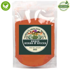 Könnte beinhalten: Ein transparenter Beutel gefüllt mit orangefarbenem Pulver, beschriftet mit "Shree Herbs & Spices". Das grüne Etikett zeigt "Create Healthy World", "Healthy Journey 2025" sowie die Logos "100% Vegan" und "Organic".