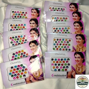 May include: Multiple packs of Chunariya brand bindi stickers, each featuring a variety of colorful, circular adhesive gems in shades of red, blue, green, yellow, and pink, displayed on white cards with images of a person wearing the bindis.
