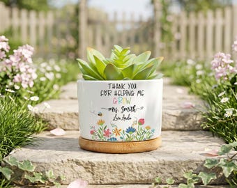 May include: A white ceramic planter with a bamboo base containing a green succulent. The planter features the text "THANK YOU FOR HELPING ME GROW" in black, "GROW" in colourful letters, "mrs. Smith" and "Love Amdia" with floral graphics.