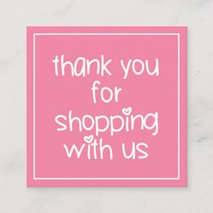 May include: A square pink card with a white border. The card features the text "thank you for shopping with us" in a handwritten style font. Small heart shapes are used as embellishments.