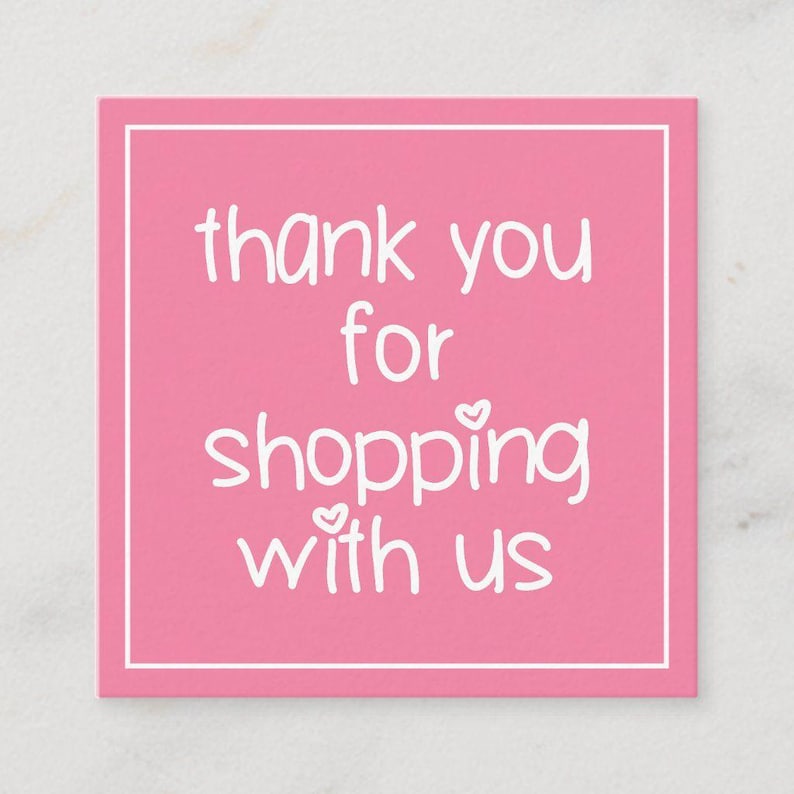 May include: A square pink card with a white border. The card features the text "thank you for shopping with us" in a handwritten style font. Small heart shapes are used as embellishments.