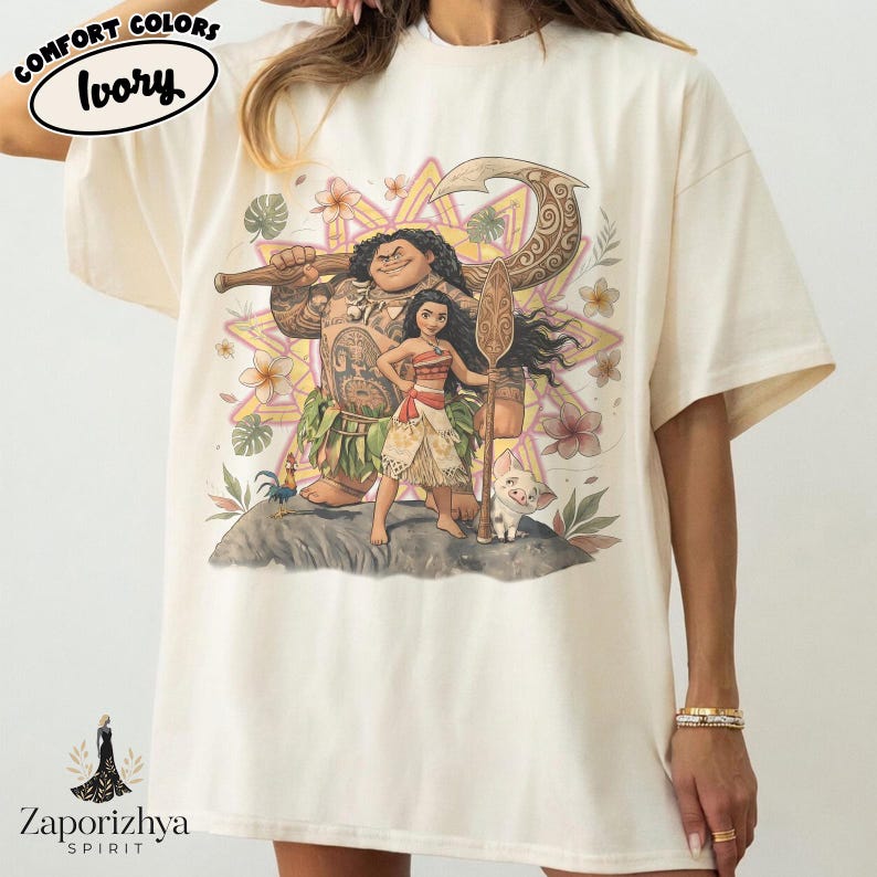 May include: Ivory-colored t-shirt featuring a colorful graphic of characters from a popular animated movie. The design includes a large figure holding a weapon, a female character, and a small pig. The shirt has the words "Comfort Colors" and "Ivory" printed on it.